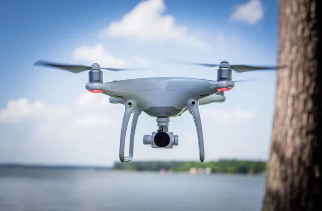 Mid-flight shot of a large white drone near a lake.