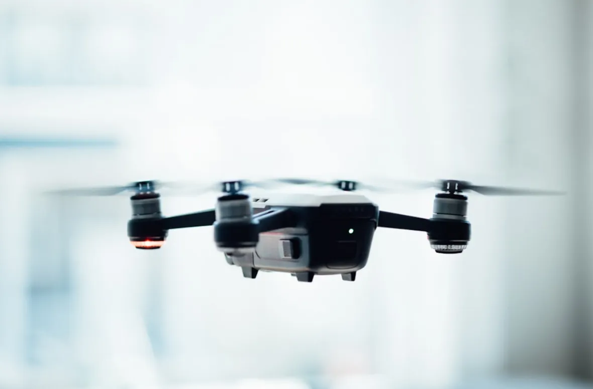 Close-up of a drone hovering indoors with blurred background.